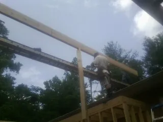 Carpenter setting a ridge beam over a new addition frame — Ice Dam Removal by Roofing Brothers in Peshtigo