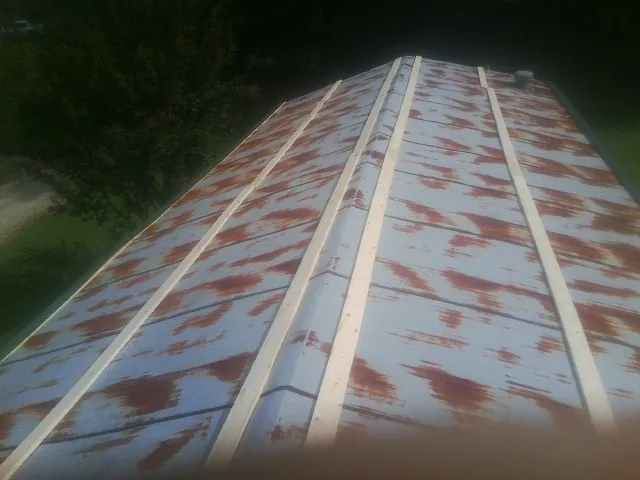 Rusted metal roof panels with new wood purlins before replacement — Storm Damage Roof Repair in Peshtigo by Roofing Brothers