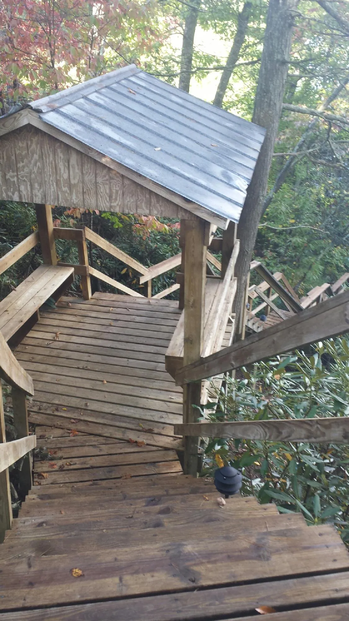Metal roofed shelter over wooden steps on a wooded walkway — Skylight Repair & Installation work by our crew in Peshtigo