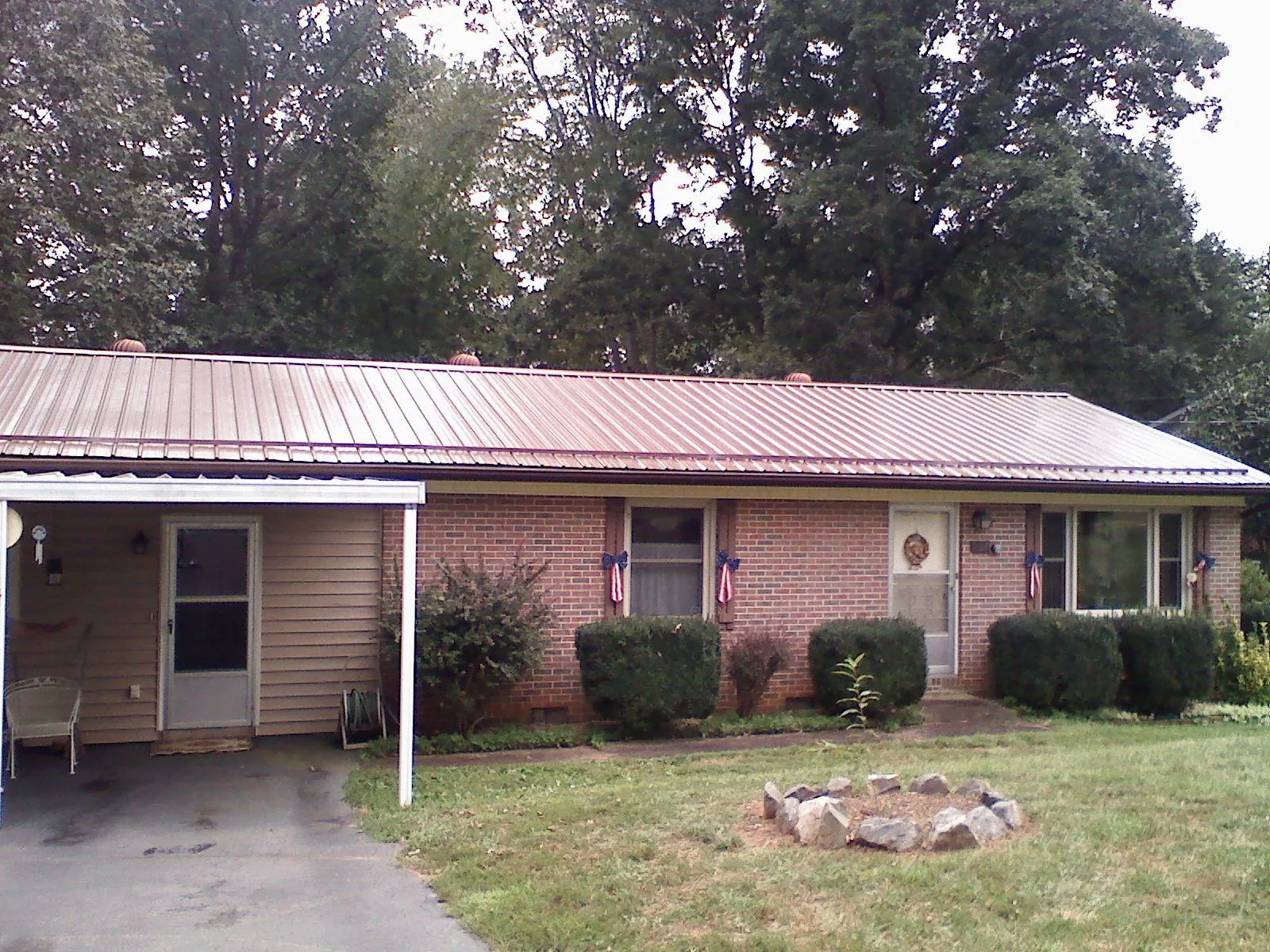 Bronze metal roof and carport on a brick ranch home — Roof Repair work by our crew in Peshtigo