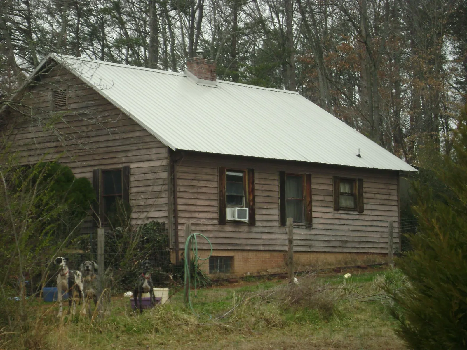 White metal roof on an old wood sided farmhouse, from a Metal Roof Installation job in Peshtigo